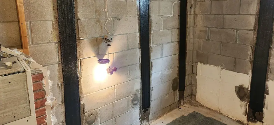 Carbon fibre straps bonded to a bowed block foundation wall to stop further movement